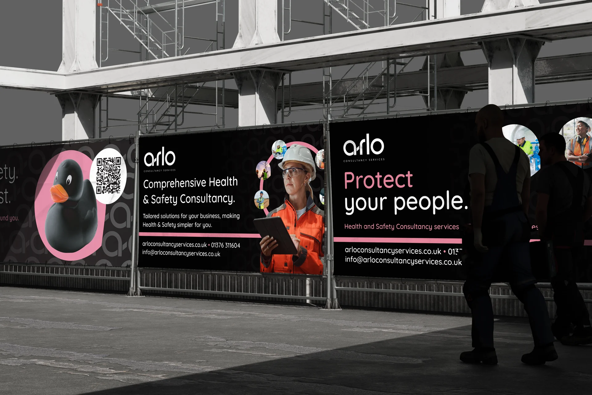 arlo vinyl banners on construction site fencing with workers walking past