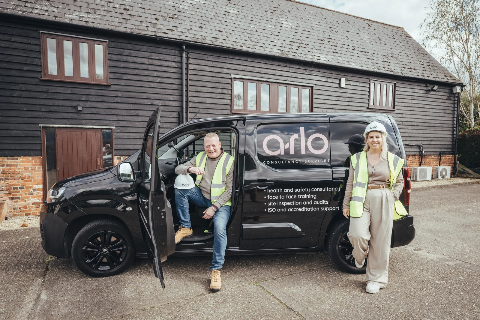 Two of the arlo team in hi-vis with the sign-written arlo van