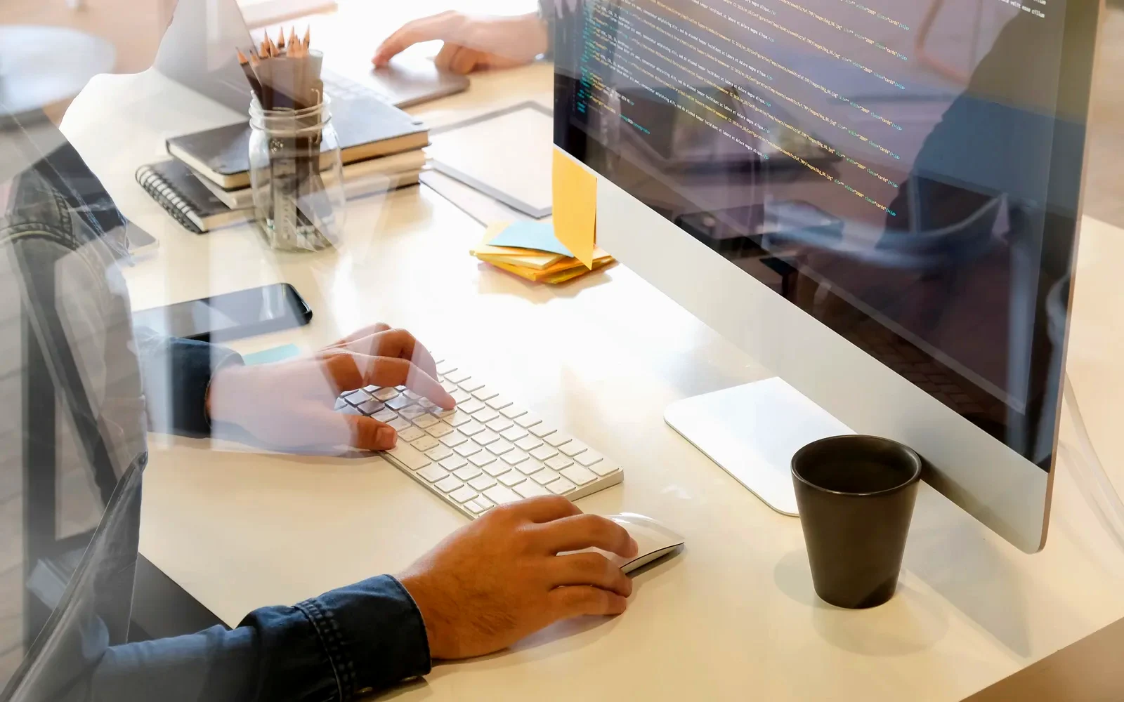 Web developer writing code for a new business website on a desktop computer